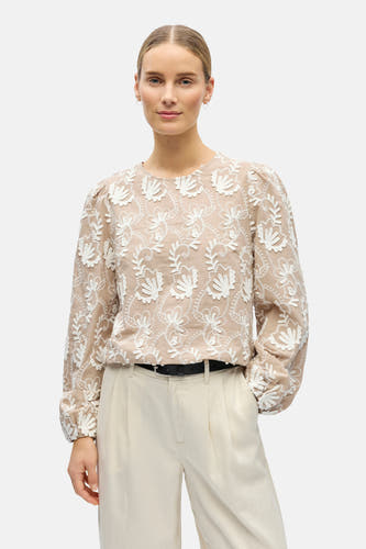Blouse beige à longues manches d'OBJECT, avec des motifs floraux brodés et des manches bouffantes, portée avec une jupe crème et des chaussures noires.