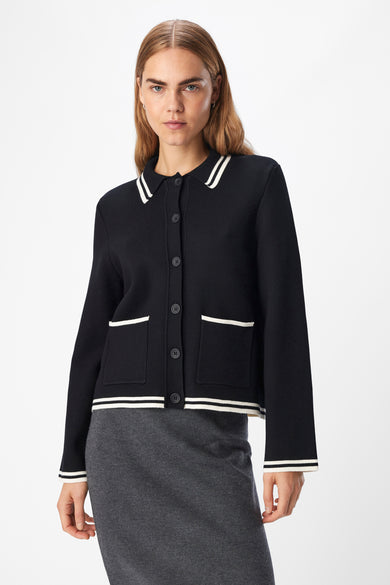 Veste noire d'OBJECT, avec des détails blancs sur le col, les poches et les extrémités.