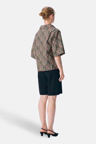 Chemise multicolore d'OBJECT, avec un motif floral, associée à des short noirs et des baskets.