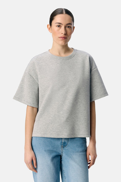 Pull-over gris d'OBJECT, avec des manches courtes et porté avec un jean bleu.
