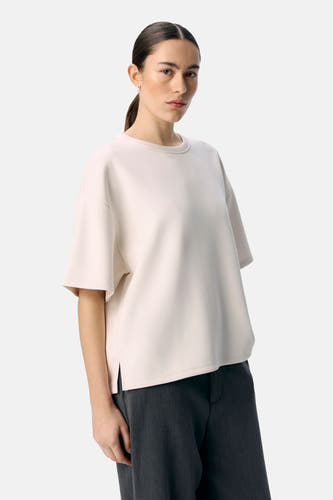 Pull écru de OBJECT, porté avec un pantalon gris et des chaussures noires.