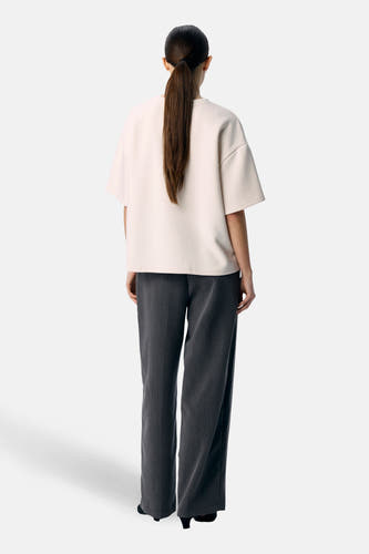 Pull écru de OBJECT à manches courtes, vu de dos, combiné avec un pantalon gris et des talons noirs.