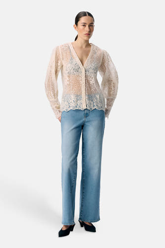 Chemise écru à longues manches d'OBJECT, avec un côté floral transparent, portée avec un jeans bleu et des chaussures noires.