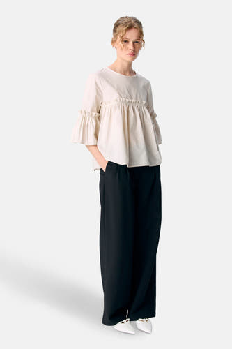 Blouse écru à manches trois-quarts d'OBJECT, avec des plis sur la poitrine et portée avec une jupe noire et des chaussures blanches.