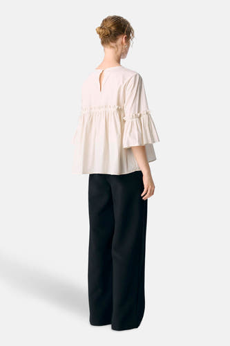 Blouse écru à manches trois-quarts d'OBJECT, avec des plis et une fermeture à bouton sur le dos, associée à un pantalon noir.