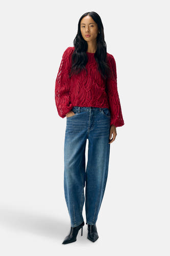 Blouse rouge à longues manches d'OBJECT, avec un motif de texture unique et portée avec des jeans larges et des bottines noires.
