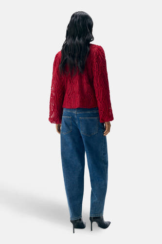 Blouse rouge à manches longues d'OBJECT, avec une texture et portée avec des jeans bleus et des talons.