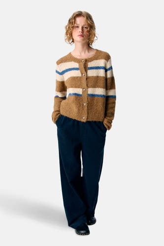 Gilet multicolore d'OBJECT, avec des rayures brunes et crème et des accents bleus, porté avec un pantalon corduroy bleu marine.