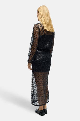 Longue jupe noire d'OBJECT, avec un motif de fleurs et des détails transparents, vue de derrière.