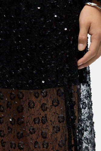 Longue jupe noire d'OBJECT, avec des strass et des fleurs brodées sur un tissu transparent.