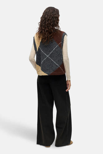 Gilet gris d'OBJECT avec motif à carreaux, porté sur une blouse blanche et un pantalon noir large.