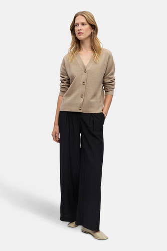 Gilet beige d'OBJECT, avec fermeture à boutons, associé à un pantalon noir et des chaussures crème.