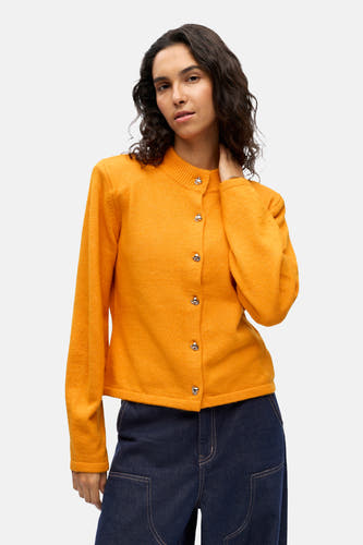 Gilet orange de OBJECT, porté avec un pantalon de denim large et foncé et des chaussures noires.