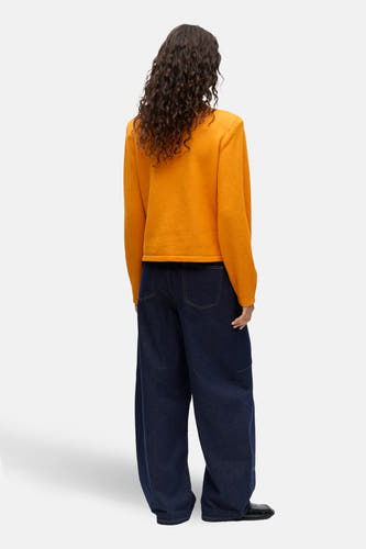 Gilet orange d'OBJECT, avec des manches longues et un jean bleu décontracté.