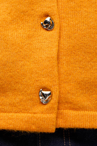 Gilet orange d'OBJECT avec des boutons argentés et une texture fine, gros plan.