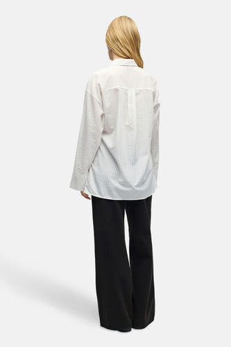 Chemise blanche à manches longues d'OBJECT, avec un motif rayé subtil, portée avec un pantalon noir large.