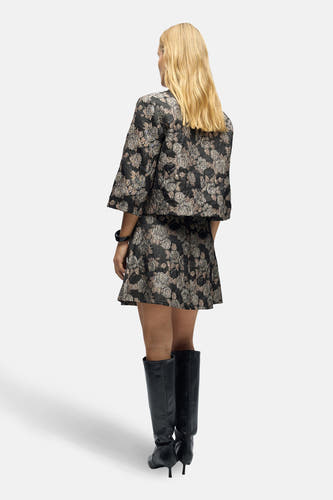 Manteau court brun d'OBJECT avec un motif floral, associé à une jupe coordonnée et des bottes noires.
