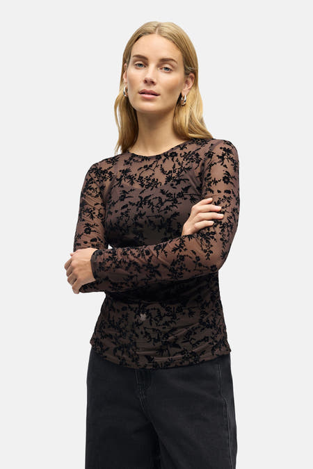 Manche à longs manches brune d'OBJECT, avec un motif floral noir et portée avec des jeans noirs larges.