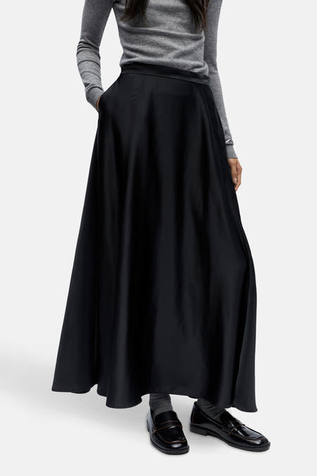 Longue robe noire d'OBJECT, avec poche et petite fente, associée à une chemise grise et des loafers noirs.