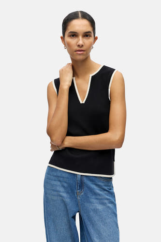 Zwarte top zonder mouwen van OBJECT, met een witte rand langs de hals en armsgaten, gecombineerd met een blauwe jeans.
