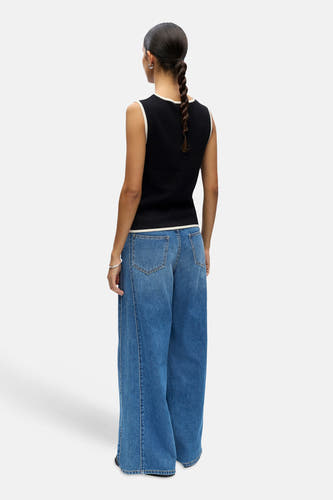 Haut noire sans manches de OBJECT, avec passepoil blanc à l'encolure et aux emmanchures, combiné avec un jean ample.