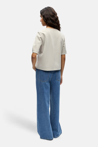 Gilet de couleur écru de OBJECT, à manches courtes, combiné avec un jean bleu évasé.