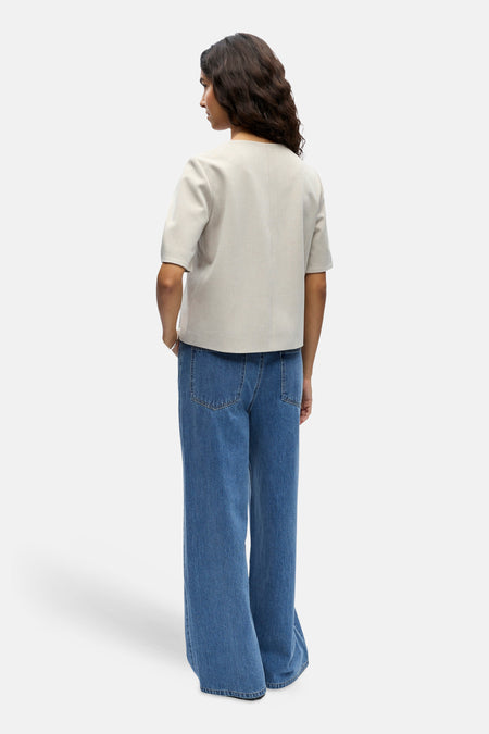 Gilet de couleur écru de OBJECT, à manches courtes, combiné avec un jean bleu évasé.