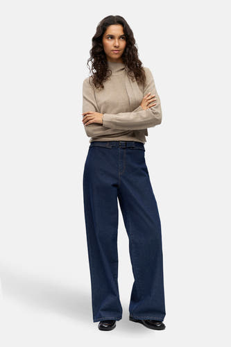 Donkerblauwe, wijde jeans van OBJECT, met een riem en een aansluitende, beige trui.
