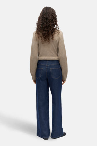 Jean bleu marine, large de OBJECT, avec des poches arrière et une taille haute, associé à une chemise beige.