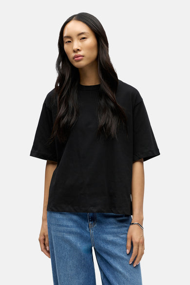 Zwart oversize T-shirt van OBJECT, gedragen door model met blauwe jeans en zilveren armband, front view