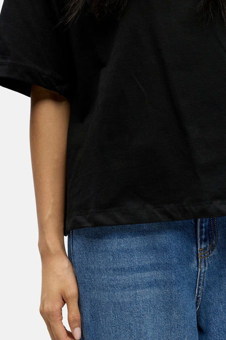 Zwart katoenen T-shirt van OBJECT, strakke pasvorm, gedragen met blauwe jeans, zijprofiel close-up