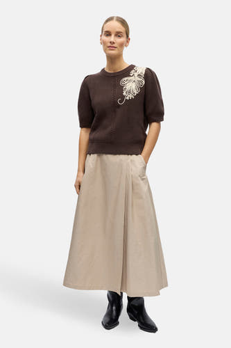 Bruine trui van OBJECT met korte mouwen en een decoratieve bloemapplicatie, gecombineerd met een lange, beige rok en zwarte laarzen.

