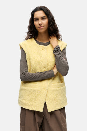 Gilet jaune d'OBJECT, avec une texture douce, porté sur un haut gris et un pantalon marron, vue arrière.