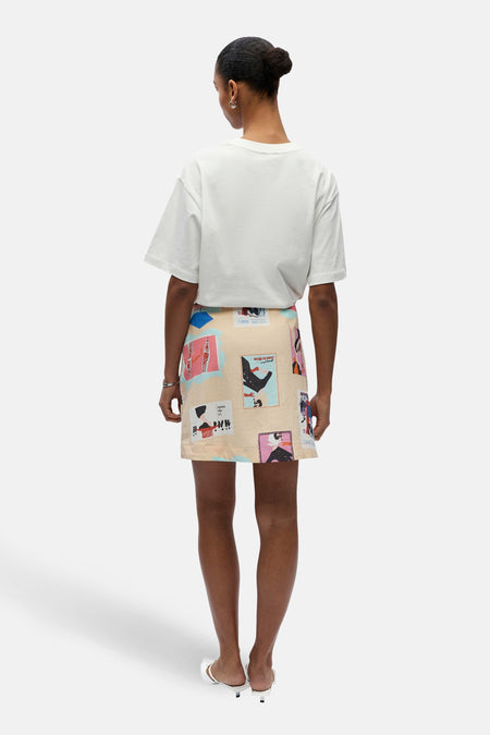 Jupe courte multicolore de OBJECT, avec un motif saisissant et associée à un t-shirt blanc et des mules blanches.