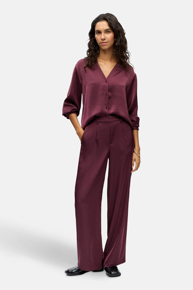 Paarse broek van OBJECT, met wijde pijpen en gedragen met bijpassende blouse en zwarte schoenen.