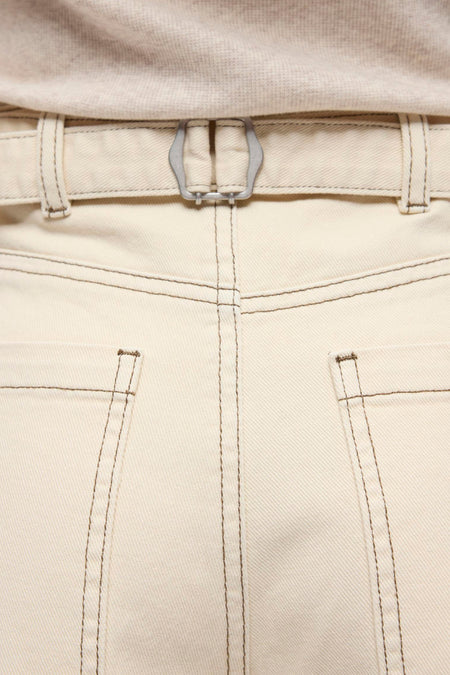 Jeans beige coupe spéciale de OBJECT, avec surpiqûres foncées, boucle argentée à l'arrière et portée avec un haut en maille fine.