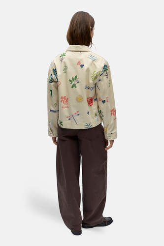 Veste courte beige de OBJECT, avec un imprimé frappant à motifs variés, combinée avec un pantalon marron et des chaussures noires.