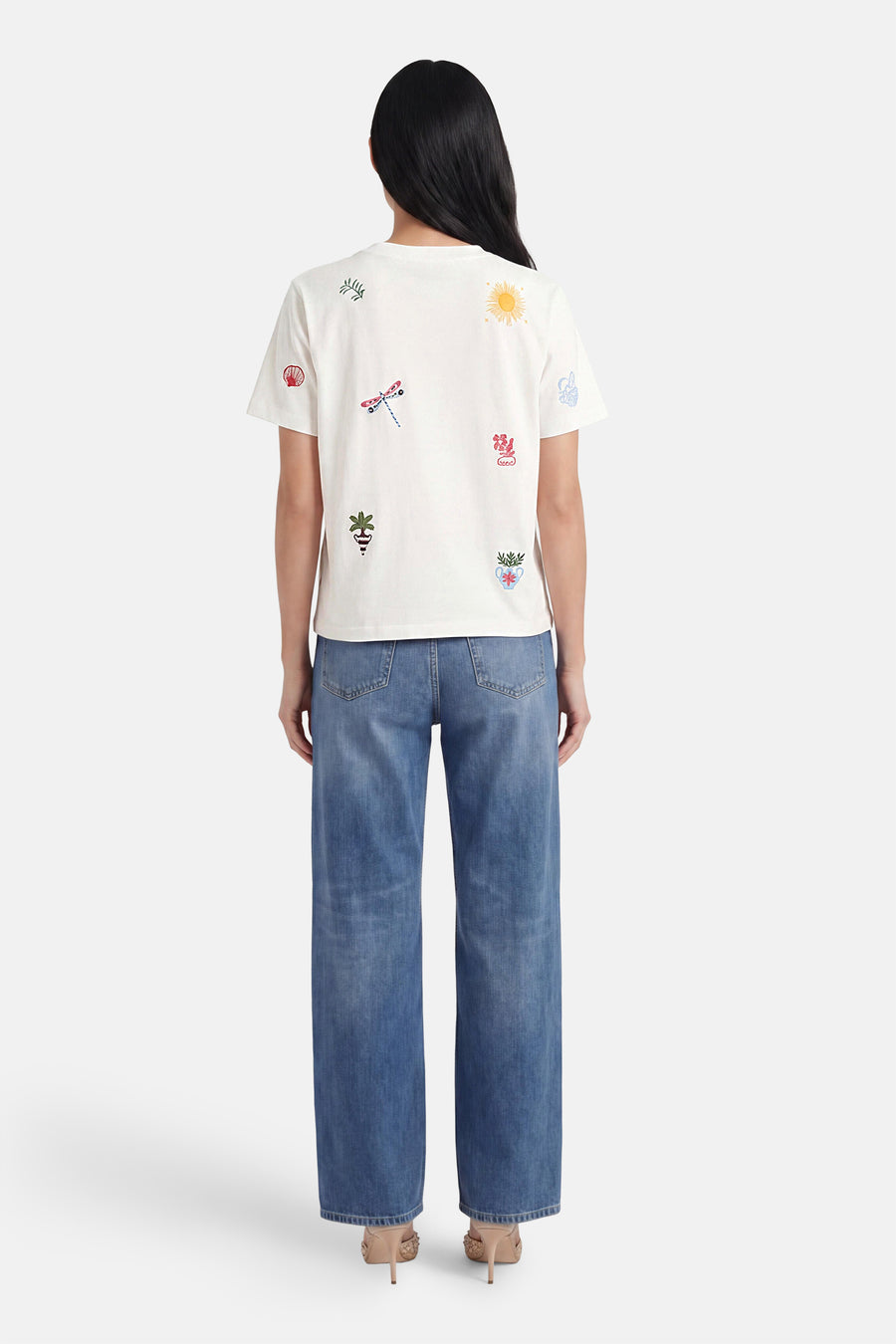 Multicolor T-shirt van OBJECT met kleurrijke geborduurde patronen, gedragen van achteren, gecombineerd met wijde jeans en hakken.
