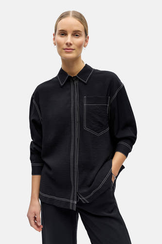 Chemise noire à manches longues de OBJECT, avec surpiqûres blanches et une poche poitrine.