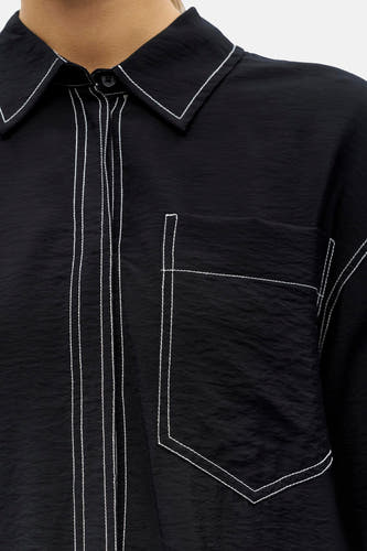 Chemise noire à manches longues de OBJECT, avec surpiqûres blanches et une poche poitrine.