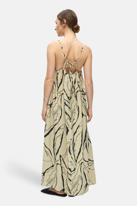 Une robe beige sans manches de OBJECT avec imprimé abstrait noir, texture froissée, dos ouvert et liens à nouer, vue de dos.
