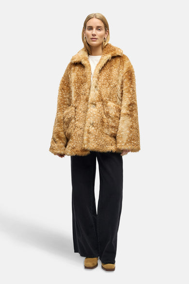 Manteau court brun d'OBJECT, avec texture en fourrure et col, porté avec un chemisier blanc et des pantalons noirs larges.