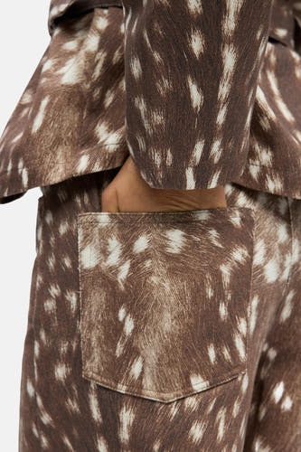 Pantalon brun d'OBJECT, avec un imprimé animal et une main dans la poche arrière.