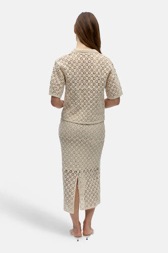 Pull écru à col en V de OBJECT, avec motif au crochet, porté avec une jupe assortie.