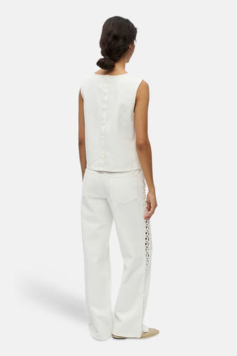 Chemisier blanc à manches courtes de OBJECT, vu de dos avec une couture, jean assorti avec détails ajourés et chaussures claires.