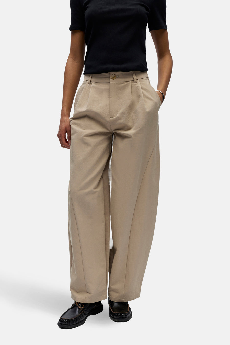 Pantalon beige de OBJECT, avec plis et jambes larges, combiné avec un t-shirt noir et des chaussures noires.