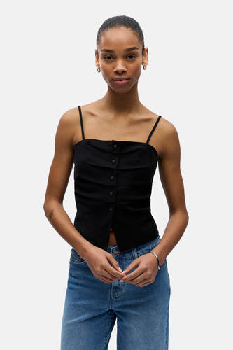 Haut noir à fines bretelles de OBJECT, avec fermeture à boutons et volants à l'avant, porté avec un jean bleu.