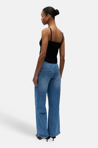 Haut noir à fines bretelles d'OBJECT, dos froncé, porté par le mannequin de dos avec un jean bleu.