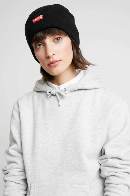 Mauvaise humeur de Levi's® Accessories, portée par un modèle avec une hoodie grise et une chemise blanche.