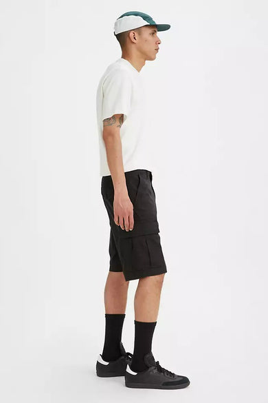 Short noir de Levi's®, vu de côté, combiné avec un T-shirt blanc couleur crème, des chaussettes noires et des chaussures, et une casquette.
